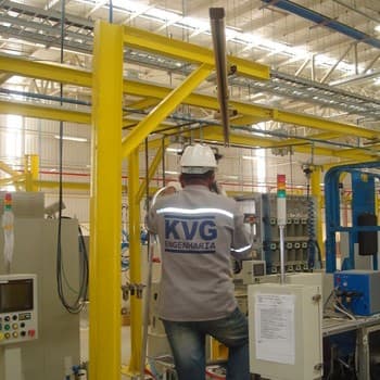 Profissional da KVG trabalhando em painel junto a estrutura metálica amarela